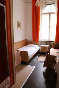 ein kleines Schlafzimmer mit einem Bett und einem Fenster in der Unterkunft Pension Reimer in Wien