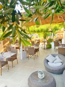 an outdoor patio with tables and chairs and a tree at Hôtel Beau Soleil in Le Lavandou
