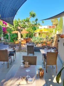 an outdoor restaurant with tables and chairs and umbrellas at Hôtel Beau Soleil in Le Lavandou