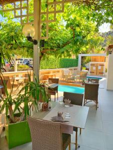 a patio with a table and chairs and a pool at Hôtel Beau Soleil in Le Lavandou