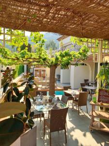 a restaurant with tables and chairs and a tree at Hôtel Beau Soleil in Le Lavandou
