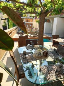 a patio with a table and chairs and a tree at Hôtel Beau Soleil in Le Lavandou