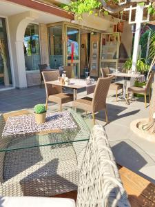 a patio with tables and chairs on a patio at Hôtel Beau Soleil in Le Lavandou