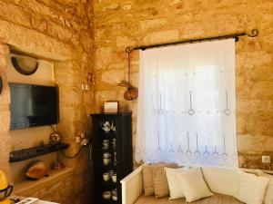 ein Wohnzimmer mit einem Sofa und einem Fenster in der Unterkunft Christakos stone house Elafonisos in Elafonisos