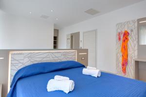 Una cama azul con dos toallas encima. en Alloggio Nella, en Rímini