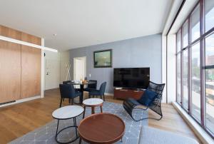 ein Wohnzimmer mit einem Tisch und Stühlen sowie einem TV in der Unterkunft Contemporary Flat near São Bento by LovelyStay in Porto