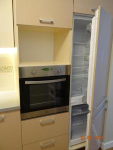 a kitchen with an oven and an empty refrigerator at JURMALA APARTMENT in Jūrmala