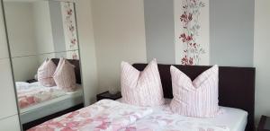 een slaapkamer met een bed met roze en witte kussens bij Ferienwohnung Kriemhild in Xanten