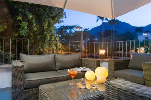 a patio with a couch and a table with wine glasses at Boutique Hotel Oriola in Cala de Sant Vicenc