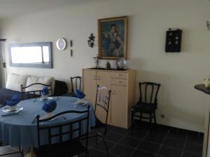 a dining room with a blue table and chairs at Residentie Aldis met zeezicht in Ostend