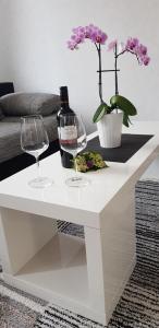 - une table basse blanche avec 2 verres et une bouteille de vin dans l'établissement Ferienwohnung Kriemhild, à Xanten