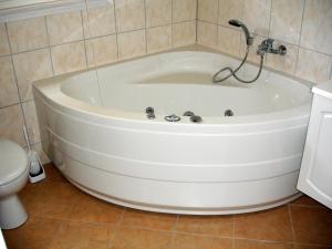 eine weiße Badewanne im Bad mit WC in der Unterkunft Strandhaus Deichkrone in Baabe