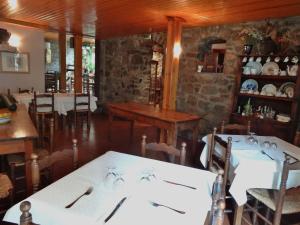 a dining room with white tables and chairs at Hostal Casa Laplaza in San Juan de Plan