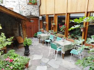 a patio with tables and chairs and plants at Hostal Casa Laplaza in San Juan de Plan