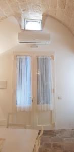 een kamer met een raam en een deur met gordijnen bij La casa di Sara in Fasano