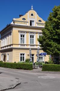 Hotel Almtalerhof في لينز: مبنى أصفر كبير عليه علامة الفندق