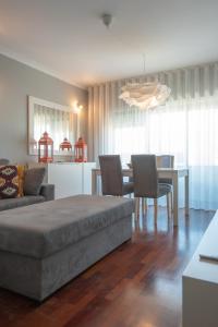 a living room with a couch and a table with chairs at Apartamento Mouzinho de Albuquerque in Matosinhos