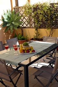een tafel met een fruitschaal en twee glazen wijn bij GIARDINO IN CITTA; CENTRALISSIMO in Sanremo