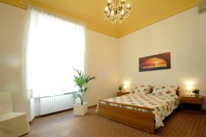 een slaapkamer met een bed en een kroonluchter bij GIARDINO IN CITTA; CENTRALISSIMO in Sanremo