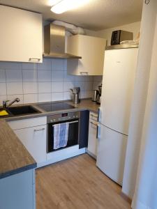 a kitchen with white appliances and a white refrigerator at Ferienwohnung Vogelvilla in Altenbeken
