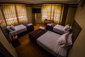 a hotel room with two beds and a table at Gran Hotel Panorama in Quillabamba