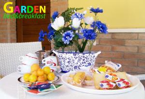 stół z talerzami jedzenia i wazonem z niebieskich kwiatów w obiekcie B&B Villa Garden w mieście Chieti