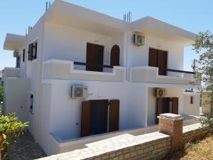 a white house with stairs on the side of it at Mihal Suites in Sarandë