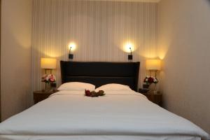 a bedroom with a large white bed with flowers on it at Style Hotel Sisli in Istanbul