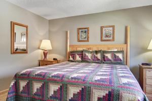 ein Schlafzimmer mit einem Bett mit einer farbenfrohen Tagesdecke in der Unterkunft The Laurel Inn in Gatlinburg