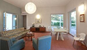 een woonkamer met een bank en een tafel en stoelen bij Dimora Villa Serena Porto Selvaggio in Santa Caterina di Nardò
