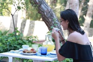 a woman taking a picture of a table with a plate of food at Dimora Villa Serena Porto Selvaggio in Santa Caterina di Nardò +37 photos
