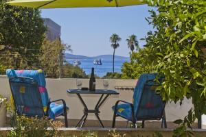 a table with two chairs and a bottle of wine at Apartments Hruban in Hvar