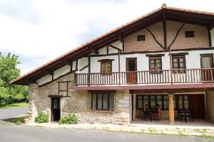 ein Haus mit einem Balkon an der Seite in der Unterkunft Albergue de Peregrinos Gerekiz in Morga