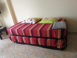 Una cama con una manta colorida y almohadas. en Jardim Paraiso Apartments en Albufeira