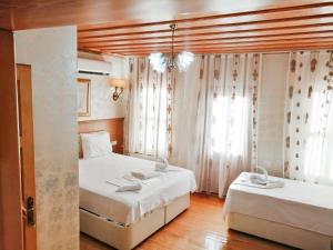 イスタンブールにあるイスタンブール　シドニー　ホテルのベッド2台と窓が備わるホテルルームです。