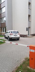 ein Auto, das auf einem Parkplatz neben einem Gebäude parkt in der Unterkunft plt&EVA in Anykščiai
