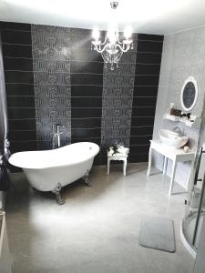a bathroom with a bath tub and a sink at Monato in Poprad