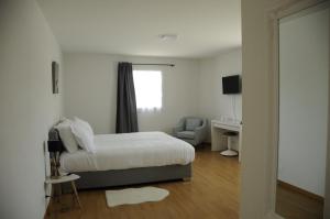- une chambre avec un lit, une chaise et une fenêtre dans l'établissement Hôtel Restaurant La Croix Verte, à Vich