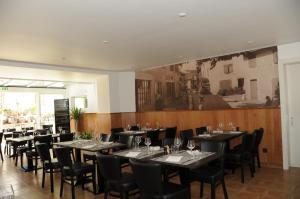 une salle à manger avec des tables et des chaises ainsi qu'une peinture murale. dans l'établissement Hôtel Restaurant La Croix Verte, à Vich