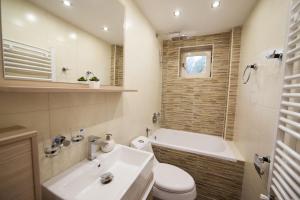 a bathroom with a sink and a tub and a toilet at Apartments Neivado in Zlatibor