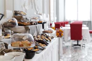 uma linha de buffet com muitos tipos diferentes de alimentos em Hotel De Ville em Génova