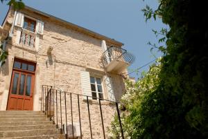 a stone building with stairs and a red door at Historic Piazza House & Romantic Hidden Garden in Hvar
