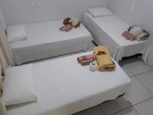 two beds in a room with towels and stuffed animals at Pousada Mãe e Filhas in Mateiros