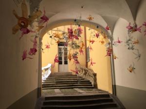 un couloir avec des escaliers et des fleurs sur le mur dans l'établissement Comolake House, à Bellano