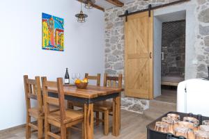 a dining room with a wooden table and chairs at Apartmani Španja in Vodice