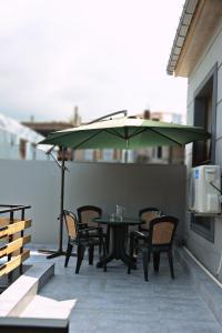 un patio con mesa, sillas y sombrilla en Apartments On Vaja Pshavela en Batumi