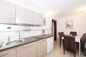 a kitchen with a sink and a table with chairs at Apartments Neivado in Zlatibor