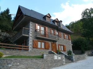 un grand bâtiment en briques avec un toit noir dans l'établissement Cap De La Vila, à Vielha e Mijaran