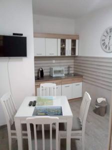 a kitchen with a table and chairs and a clock at Tara Deluxe Apartment in Budva