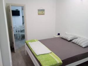 a bedroom with a bed with a green blanket at Tara Deluxe Apartment in Budva